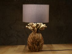 a wooden table with a lamp on it and a pineapple shaped object in the center