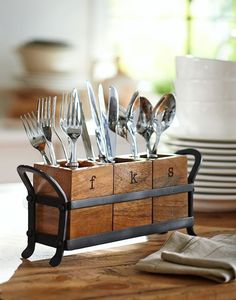 a wooden box with forks and knives in it