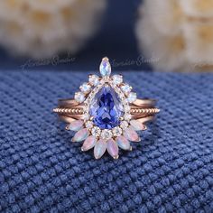 Vintage Pear Cut Conrnflower Sapphire Engagement Ring Set Rose Gold Moonstone Wedding Rings 3pcs Halo Ring Opal Bridal Set Anniversary Gifts Jewelry Information: ♡ Handmade, high-quality item ♡ Material: SOLID 14K/18K GOLD ( can be made in yellow/white/rose gold ) ♡ Center stone: Lab grown sapphire ♡ Size/Weight:  8x6mm ♡ Cut - Pear Shaped ♡ Color: Cornflower blue ♡ Side stones: Moissanite/ Natural diamonds ♡ Weight:  About 0.21ct ♡ Cut - Round Shaped ♡ Clarity - SI-VS ♡ Color- G-H ♡ Band Width: Around 1.6mm ♡ Top Wedding band  ♡ Stone: Moonstone ♡ Color- Blue ♡ Cut - Marquise & Round Shaped ♡ Band Width: Around 1.6mm ♡ Bottom Wedding Band ♡ Stone: Natural Australia Opal ♡ Color: White with fire ♡ Band Width: Around 1.6mm Visit my shop for more jewelry: https://www.etsy.com/shop/acraisejew Cornflower Sapphire Ring, Moonstone Wedding Ring, Opal And Sapphire Ring, Opal Wedding Band, Sapphire Engagement Ring Set, Opal Wedding, Ring Opal, Sapphire Engagement Ring Blue, Engagement Rings Opal