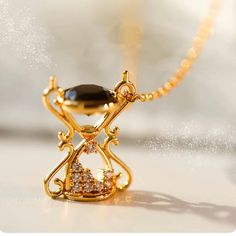 The 14K gold brass hourglass necklace features a unique and elegant design. Crafted from high-quality 14K gold, this necklace exudes a luxurious and timeless appeal. The hourglass pendant serves as the focal point, symbolizing the passage of time and the beauty of each moment.  Adorning the necklace are intricate decorative elements embellished with Zircon stones. These Zircon gemstones, known for their brilliance and clarity, add a sparkling touch to the necklace, enhancing its overall aesthetic. The combination of the 14K gold and Zircon accents creates a harmonious blend of sophistication and glamour. With its delicate chain and adjustable length, this necklace is versatile and can be customized to suit individual preferences. It serves as a stunning accessory for both formal and casual Hourglass Necklace, Hourglass Pendant, Delicate Chain, Decorative Elements, Memorial Jewelry, Gold Brass, Necklace Vintage, Vintage Necklace, Focal Point