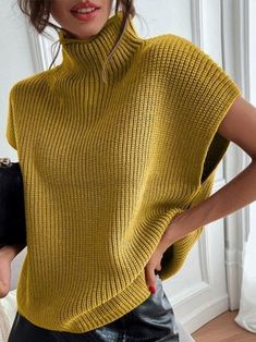 a woman wearing a yellow turtle neck sweater