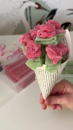 a person is holding a bouquet of flowers made out of an old book page and tissue paper