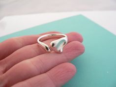 Overview:Here's the perfect cute little ring for you -- Also a great way to say "I love you" or I love me" :).  Offered for sale is a gorgeous and rare Tiffany & Co Sterling Silver Elsa Peretti Full Heart ring.  I am 100% positive that you will want to use it over and over again. Your friends will be fascinated by this gorgeous piece – it is almost like a work of art! The look of the piece is simple, playful, and very distinct.  The ring is very comfortable to wear, and is in very good condi Sterling Silver Open Heart Ring For Proposal, Sterling Silver Heart Ring For Valentine's Day Proposal, Tiffany Co Rings, Perfect Cute, Solitaire Diamond Pendant, I Love Me, Toggle Necklace, Solitaire Pendant Necklace, Elsa Peretti