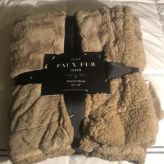 the faux fur throw is laying on top of a bed