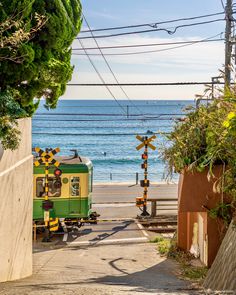 a small train is going down the tracks by the beach