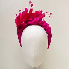 FABRIC This Women's fascinator headband has been carefully crafted and covered in magenta duchess satin and features a beautiful complementary feather corsage. The internal band is slightly padded particularly around the tips which ensures a comfortable wear at your special event. This bespoke handmade head crown is light, soft and super comfortable and boasts a quality  luxurious, sustainable finish.  FIT and SIZE A flexible base band to fit all head sizes. I do not use cheap synthetic velvetee Pink Feather Trim Mini Hat For Evening, Pink Mini Hat With Feather Trim For Evening, Pink Feathered Fascinator For Races, Pink Feathered Fascinator For Evening, Fitted Pink Fascinator With Feather Trim, Adjustable Pink Mini Hat With Feathers, Pink Feather Trim Fascinator For Royal Ascot, Pink Feather Trim Headpieces For Party, Pink Feather-trimmed Costume Hats For Royal Ascot