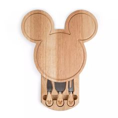 a wooden mickey mouse head cutting board with knifes and utensils in it