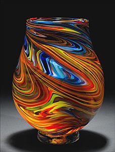 a colorful glass vase sitting on top of a table