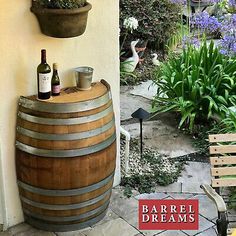 there is a wine barrel on the wall next to a potted plant and some bottles