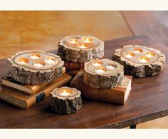 four wooden logs with lit candles sitting on top of each other in front of a book