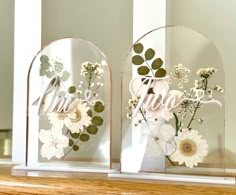 two clear vases with flowers and the word love on them