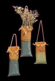 three vases with flowers in them sitting next to each other on a black background