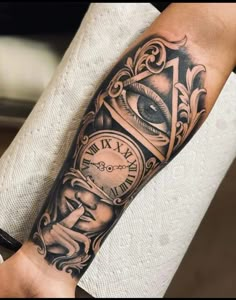 a man's arm with a clock and an eye tattoo on the arm,