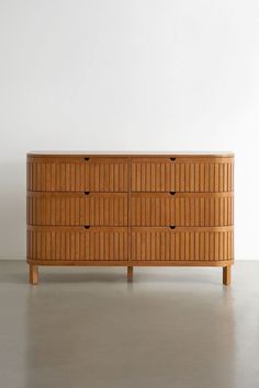 a wooden dresser sitting on top of a white floor