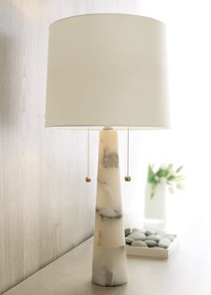 a white lamp sitting on top of a wooden table