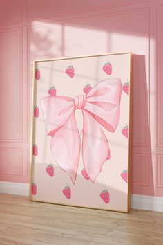 a painting with a pink bow and strawberries on it in front of a pink wall