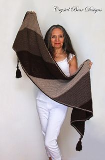 a woman holding up a brown and black shawl