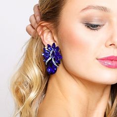 Description Meant to be oversized and extravagant, these teardrop stone clip-on earrings are the perfect way to make waves in the fashion world. Large statement clip-on earrings with a tropical inspired design, lined with bright, sparkling royal blue stones and silver plating. Beautiful, shiny, sophisticated jewelry to add towards your accessories collection. Size • Clip-on earrings.• Length: 2.25 in (5.72 cm)• Width: 2.75 in (6.99 cm) Quality Made from high-quality lightweight, solid metal allo Sophisticated Jewelry, Pearl Shop, Make Waves, Blue Stones, Holiday Essentials, Pearl Set, Accessories Collection, Fashion World, Blue Earrings