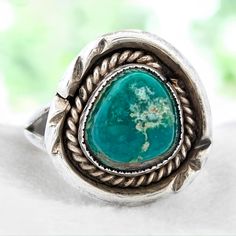 Introducing the Buzzard's Roost ring, a vintage sterling silver piece that features a stunning split shank design, hand stamped ring top, and an intricate interior twisted wire motif. The centerpiece of this unique ring is a beautiful green turquoise stone. Sized at 6, this ring combines the elegance of vintage jewelry with the quality of artisan craftsmanship. The hand stamped top and twisted wire details add a distinctive charm, while the green turquoise adds a vibrant touch. Perfect for those who appreciate bespoke, high-quality jewelry, the Buzzard's Roost ring is a standout piece in any collection. Whether for special occasions or everyday wear, this handcrafted sterling silver ring with its split shank design, hand stamped top, twisted wire motif, and green turquoise, size 6, offers Stamped Ring, Hand Stamped Ring, Stamped Rings, Vintage Sterling Silver Rings, Twisted Wire, Split Shank, Unique Ring, Silver Pieces, Green Turquoise