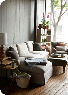 a living room filled with furniture and lots of wood flooring on top of a hard wood floor