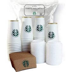 starbucks coffee cups are stacked on top of each other in front of a cardboard bag