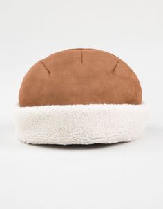 a brown and white hat on top of a white surface with the bottom part of it covered in fur