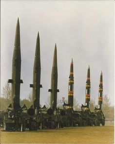 a group of missiles sitting on top of each other in the middle of a field