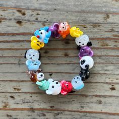 a bracelet made out of glass bears on a wooden table with wood planks in the background