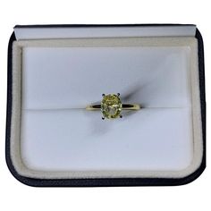 a yellow diamond ring in a white box