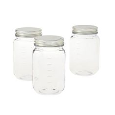 three glass jars with silver lids on white background