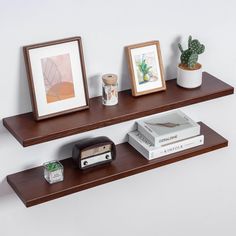 two wooden shelves with pictures and books on them