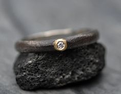 About this ring: *Ready to ship *Made by hand by me in my Vancouver, Canada home studio *Size 7.5 *3mm wide band  *Reticulated sterling silver band, oxidized *18k yellow gold flush bezel setting *1.7mm VS1 white diamond This size 7.5 ring is ready to ship.  I created a reticulated 3mm wide band from sterling silver, and built an 18k yellow gold bezel for the diamond.  Reticulation is a process whereby you bring the metal to molten, quickly quench it, and repeat until the desired organic texture Hand Forged Diamond Rings For Promise, Hand Forged Diamond Ring For Anniversary, Hand Forged Diamond Promise Ring, Hand Forged Diamond Anniversary Ring, Hand-forged Diamond Anniversary Ring, Hand Forged Diamond Ring As A Gift, Hand Forged Diamond Ring For Gift, Unique Single Diamond Ring As Gift, Unique Single Diamond Promise Ring