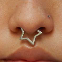 a close up view of a nose with an arrow piercing on it