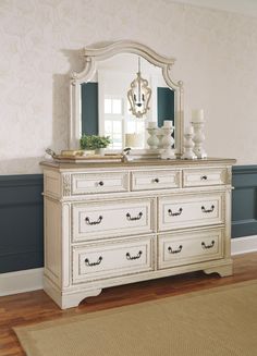 a white dresser with a mirror on top of it