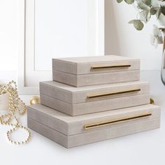 three wooden boxes sitting on top of a table next to a vase with flowers in it