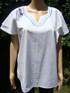 Hand Made Tunic, 100% cotton fabric with embroidered designs.  this hand made tunic can be hand or machine wash. This garment need to be iron after every wash to maintain its shape and beauty.  Comfortable and durable, this Tunic was created out of 100% cotton fabric.  The fabric will softened after every wash. White Embroidered Cotton Tunic Top, White Cotton Embroidered Tunic Top, Cotton Tunic Top With Embroidered Neckline, White Cotton Tunic With Floral Embroidery, Folk Style Cotton Blouse With Machine Embroidery, Cotton Folk Blouse With Machine Embroidery, Cotton Tunic With Embroidered Hem, Embroidered Hem Cotton Tunic Blouse, Traditional Cotton Tunic With Embroidered Neckline