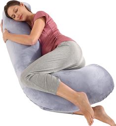 a woman is laying on a large pillow