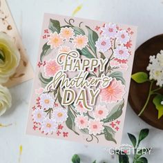 a mothers day card with flowers on it next to some flowers and a cup of coffee