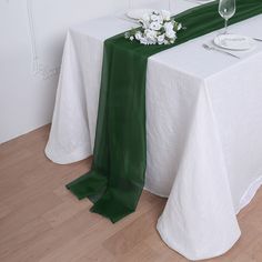 the table is set with white and green linens