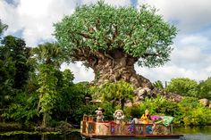 people on a boat ride in front of the tree of life at disney's animal kingdom