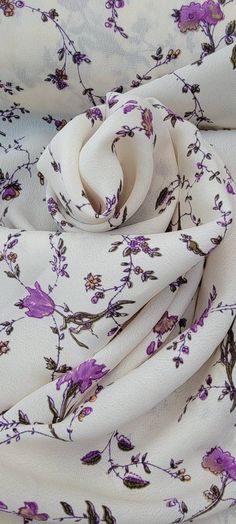 the fabric is white with purple flowers on it