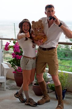 a man and woman posing for a photo on a balcony