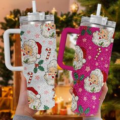 two christmas themed tumblers with santa and candy canes on them, one is pink