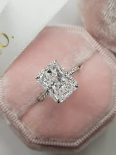 a cushion cut diamond engagement ring in a pink velvet case