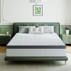 a green bed in a white room with two nightstands and a painting on the wall