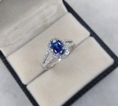 a blue and white diamond ring in a box