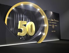 the 50th anniversary sign is lit up in front of a black backdrop with gold lettering