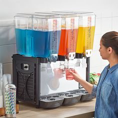 a woman standing in front of a machine filled with drinks