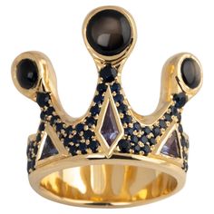 One of a Kind Crown Ring encrusted with blue sapphires and topped with Black Star Sapphires. This sculptural ring makes a bold statement and is a wearable work of art. If you like this ring, check out the companion piece in our collection. Listing Title: Hand carved Sterling Silver with Gold Ring on Ring • Hand carved 10 karat yellow gold • 3 x Black Star Sapphire, cabochon • Pavé set blue sapphires, 1.2 Approximate Total Carat weight • Ring size: 10 • Total weight: 19.84 grams • Made in Canada Gold Sapphire Ring Star, Black Star Sapphire Ring, Black Star Sapphire, Male Crown, Sculptural Ring, Star Sapphire Ring, Sapphire Cabochon, Custom Jewellery, Antwerp Belgium