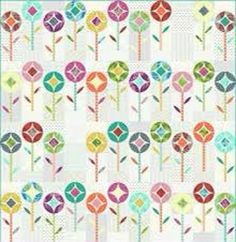 a quilt with colorful flowers and leaves on the front, as well as a white background